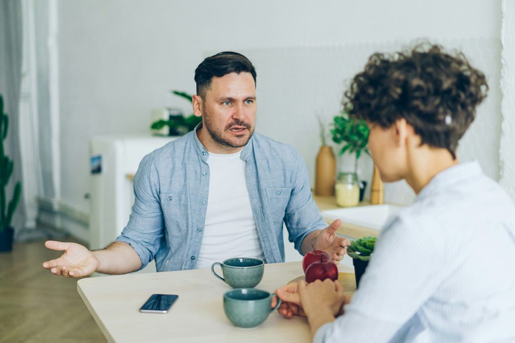man yelling at woman at breakfast table
